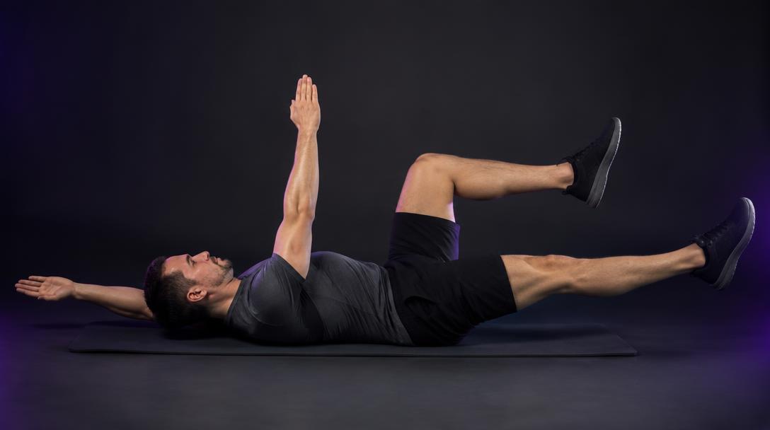 Dead-Bug Reach: Man lying on his back extending the opposite arm and leg with a flat low back