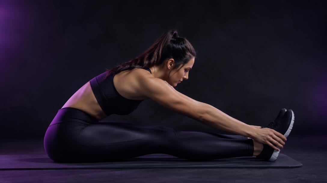 Seated Hip-Hinge Fold: Woman sitting with legs straight, folding forward from the hips with a long spine